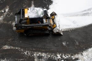 Snow removal equipment clearing snow from a commercial property in Pennsylvania, highlighting professional snow and ice management services.